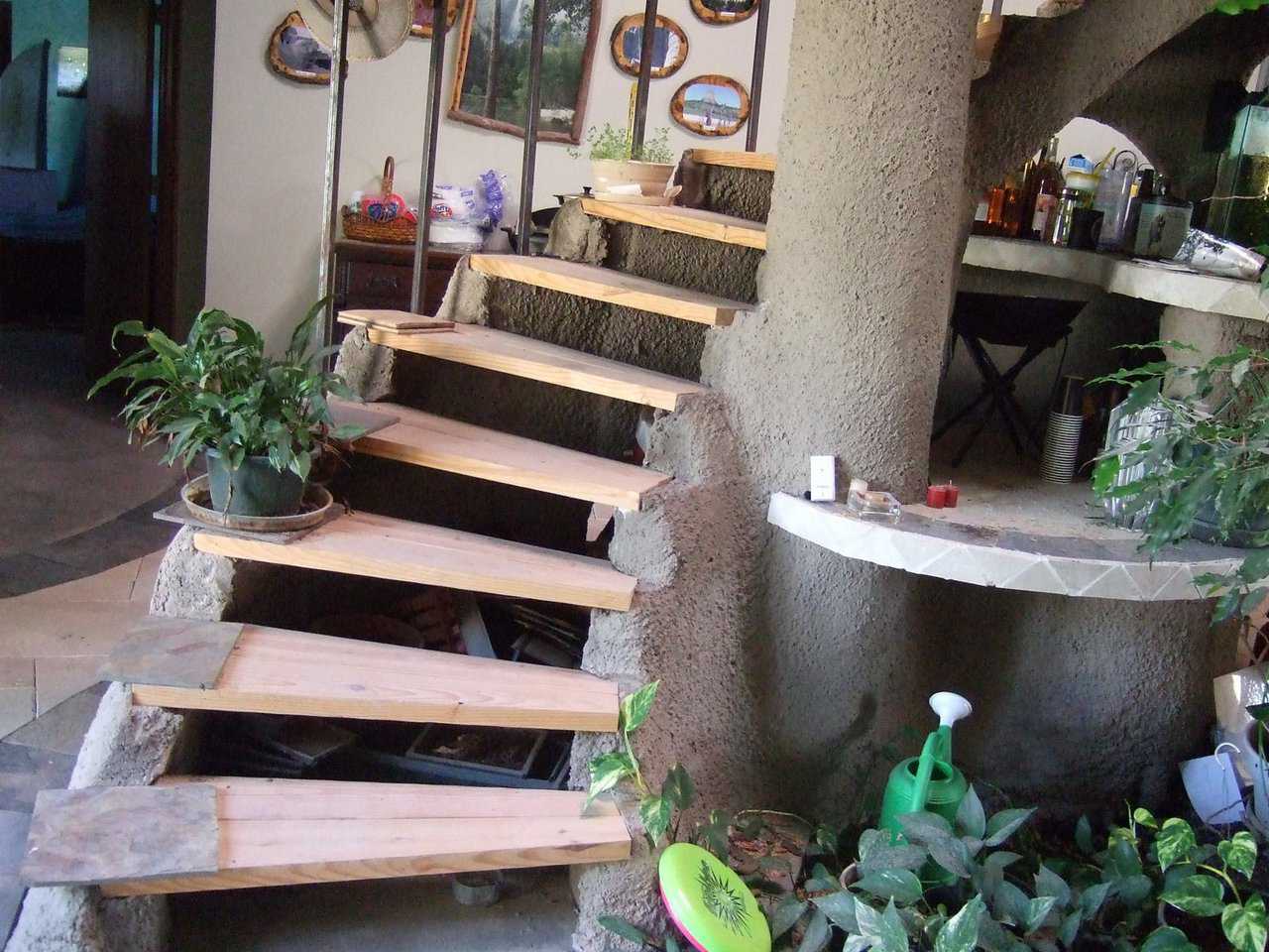 Slate staircase.   — It spirals over an aquarium and down into the main living area of this underground dome.