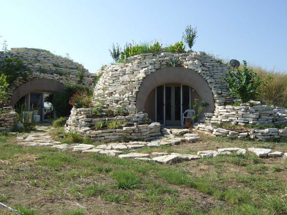 Retaining wall.  — A multi-level rock retaining wall surrounds the domes and creates gardens planted with flowers, greenery and berries.