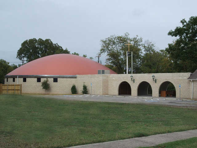 Architectural blending — A long wall connects St. Joseph’s new Monolithic Dome church with the original church, a small, traditional structure that now serves as the Parish Hall. Both the connecting wall and the stemwall of the dome are made of cut face block that looks like brick.