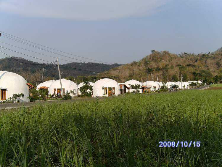 EcoShell Clusters — DFTW trained native workers to build Monolithic EcoShell Domes. Constructed of concrete, reinforced with steel, EcoShells provide clean, low-energy use, fire-and disaster-resistant homes and public buildings. These dome-homes are arranged in clusters of 12.