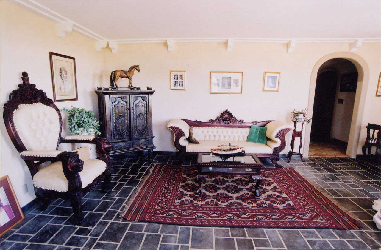 The Living Area — It features Spanish-style furniture, stamped and stained concrete flooring and arched doorways.