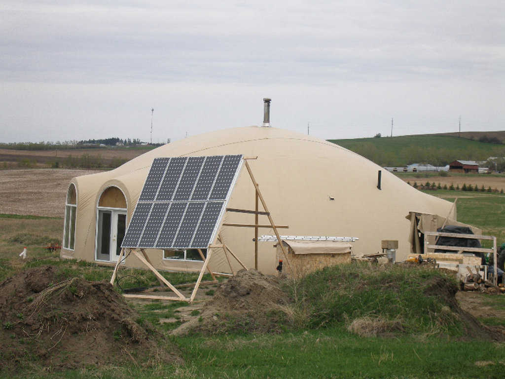 A Passive Solar house — Sun shines through south-facing windows, heats the floor and the concrete blocks, and the warm air naturally circulates through the blocks and the dome, thus heating the dome.