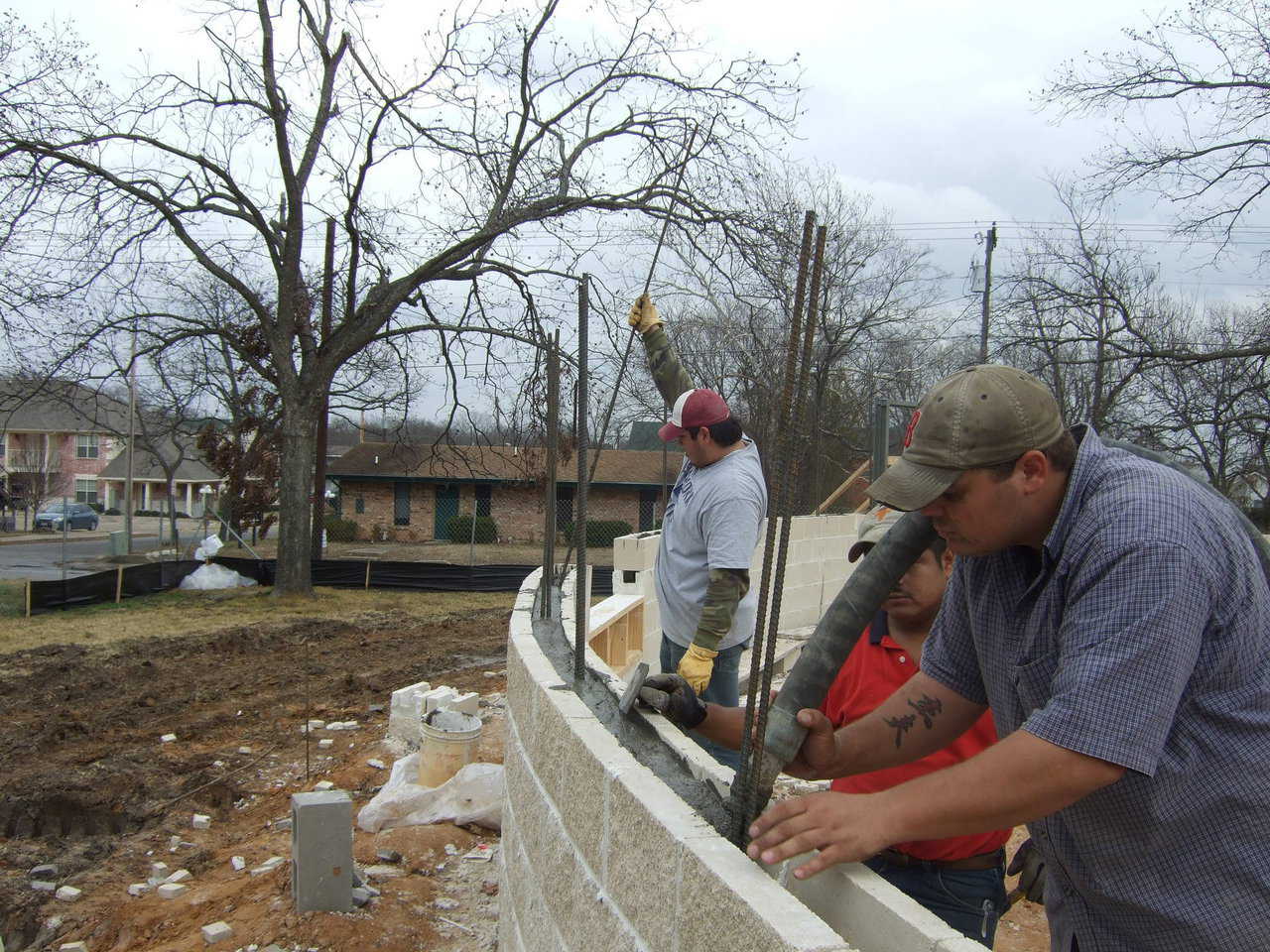 The crew is filling the cores of the first course of block. The concrete was also mixed with the same mixer, just a different mix design. The concrete is being pumped into the walls using the GHP2500 concrete pump.
