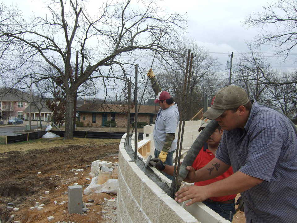 The crew is filling the cores of the first course of block. The concrete was also mixed with the same mixer, just a different mix design. The concrete is being pumped into the walls using the GHP2500 concrete pump.