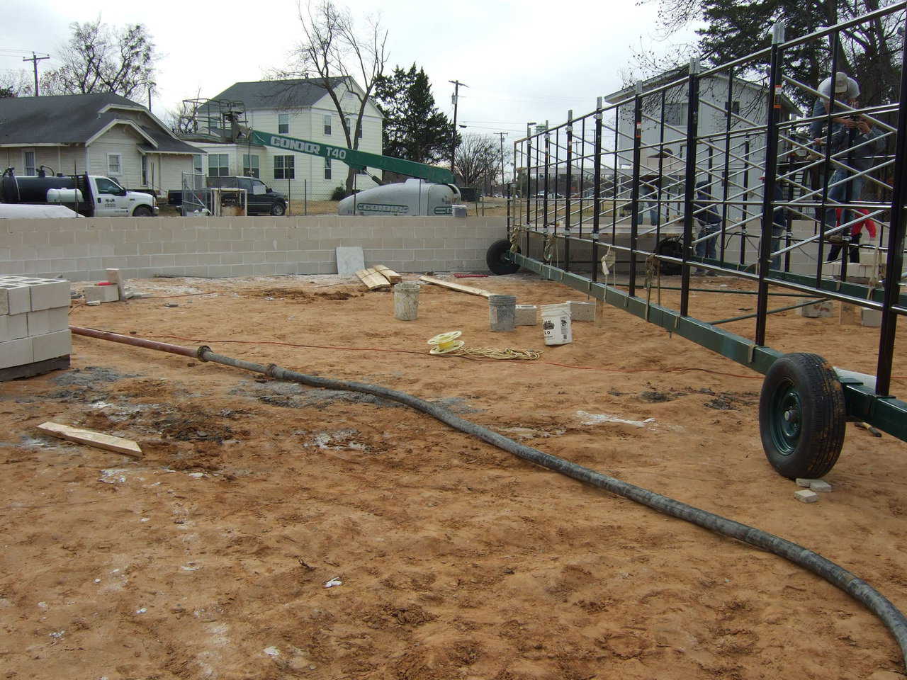 In this image, you can see the Paxis rotating scaffold that will be later used to build the dome, but came real handy when it came to building the walls. Also, you can see the concrete hose coming from the pump area.