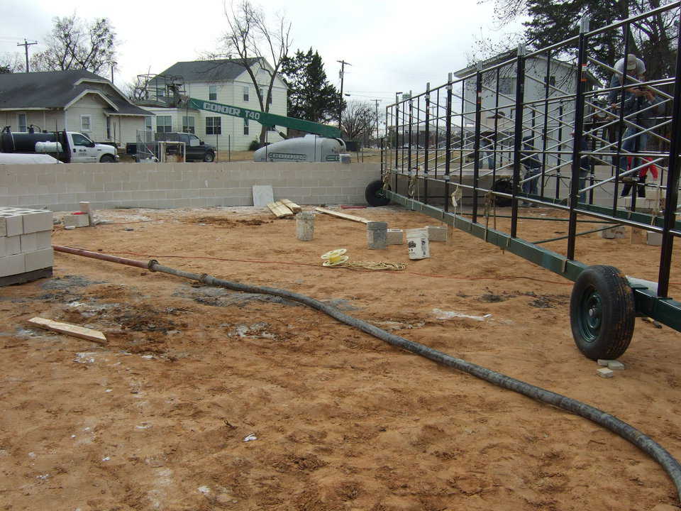 In this image, you can see the Paxis rotating scaffold that will be later used to build the dome, but came real handy when it came to building the walls.  Also, you can see the concrete hose coming from the pump area.