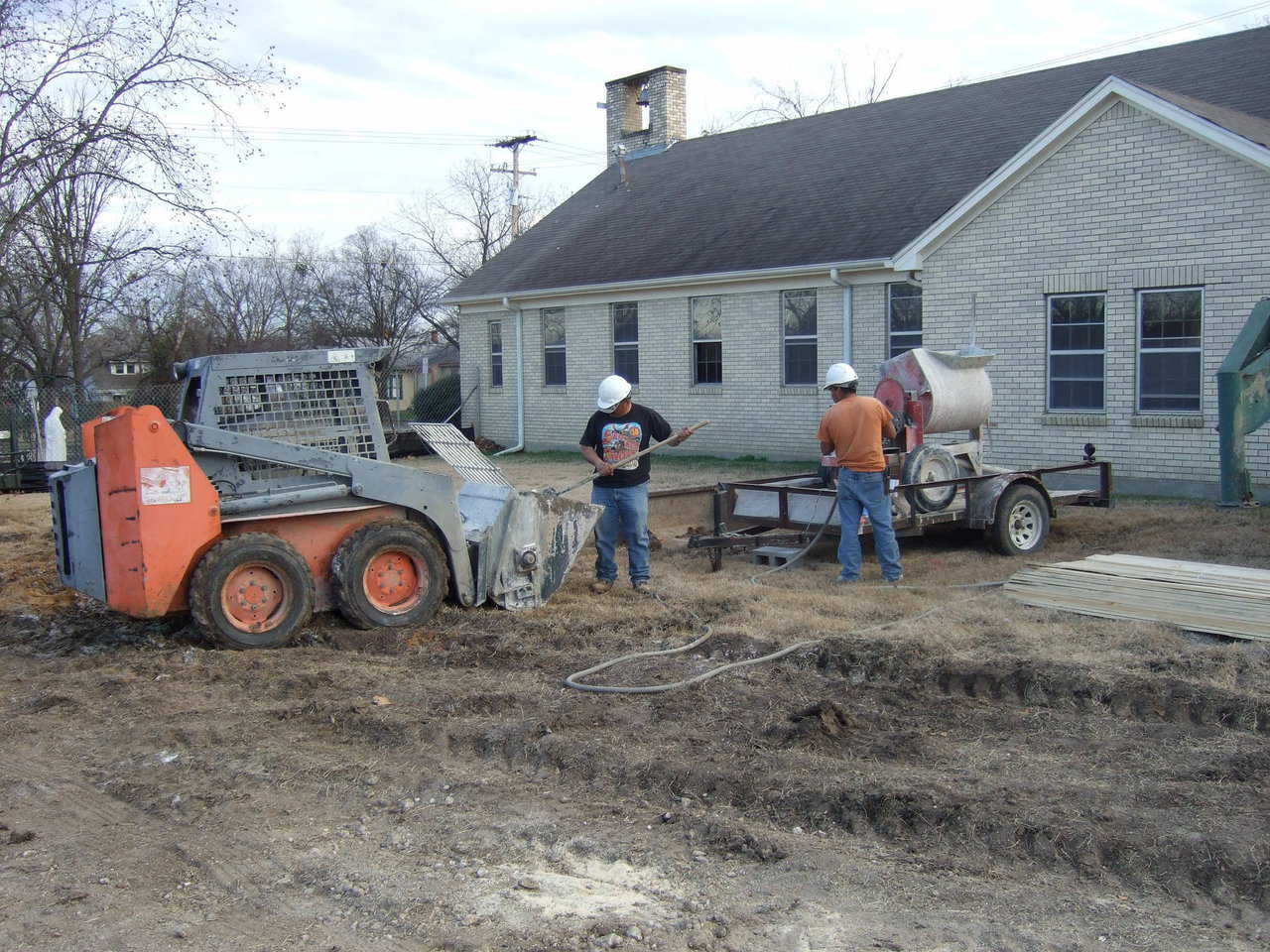 Here the men have loaded the mix and are cleaning the hopper, and adding more epwater until the mix is just how they want it. Another advantage of the mixer is that the sand, water, and cement don’t necessarily have to be in the same location.