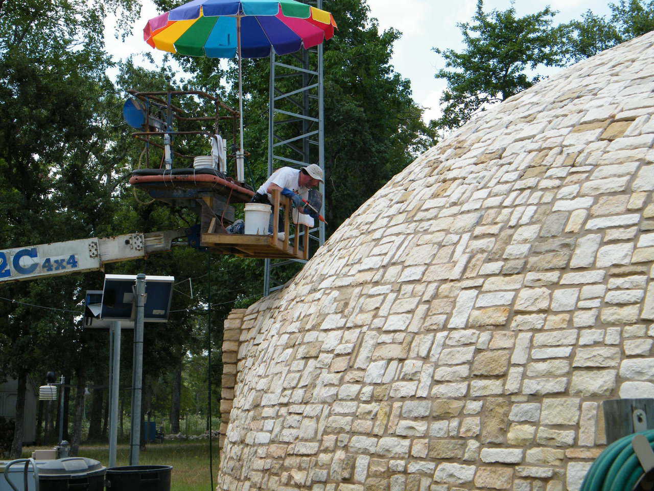 Getting up there! – To stone the very top of the dome, the Tassells used a manlift, loaned to them by Amy and Bob Brooks. 
