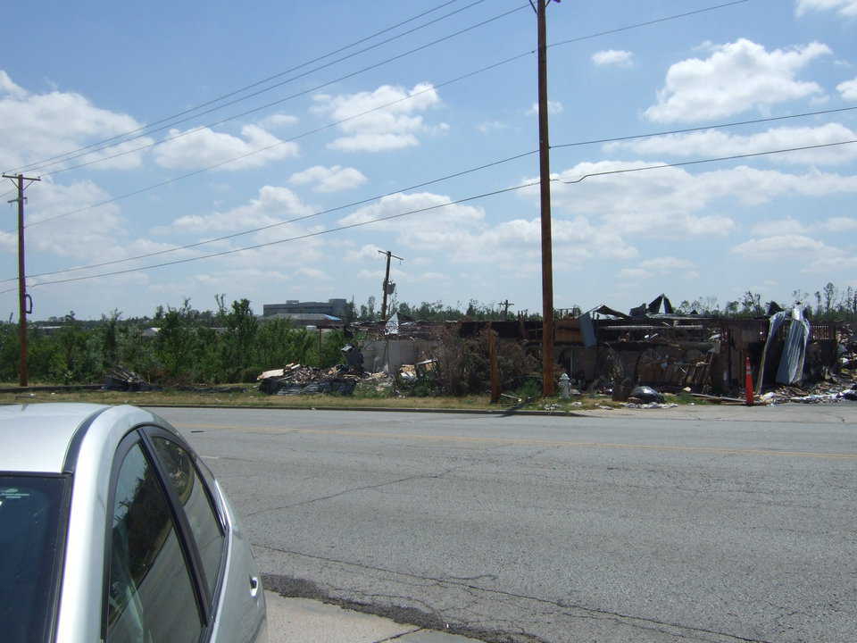 In the background, there is a hospital that survived but in need of much repair.