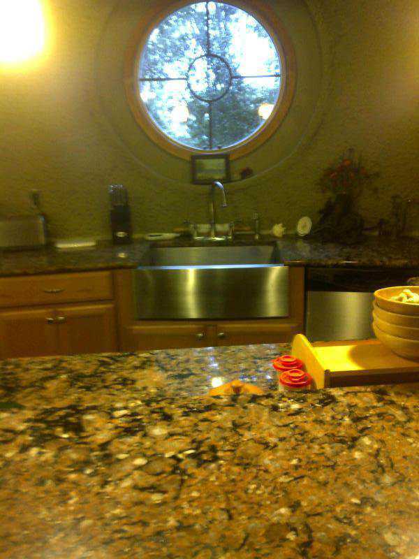 The kitchen has a pretty, round window just above the sink.