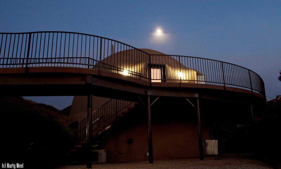 An elevated walkway connects the Monolithic Dome home with the dome garage that’s topped by a guest apartment.