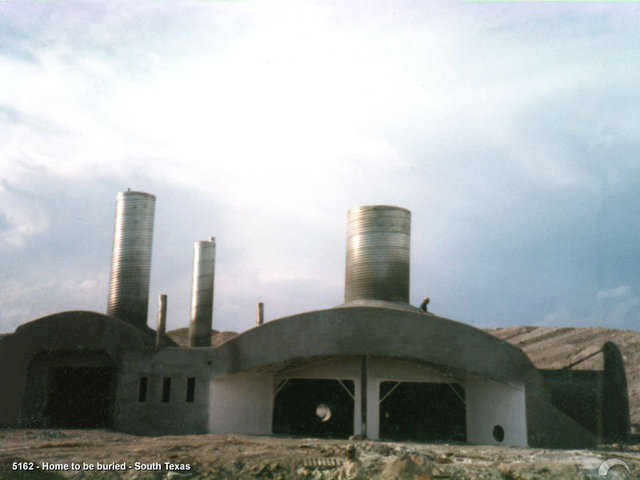 This home under construction. It was built in 1987 and  is truly a nuclear fallout shelter.  The earth cover goes to the top of the pipes.  For more information see the John Ayers article.
