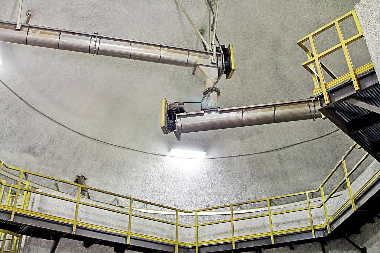 Pictured here is the rotating distribution conveyor. The top conveyor brings material from the outside elevators, drops it into the rotating conveyor, then delivers it to a specified bin.