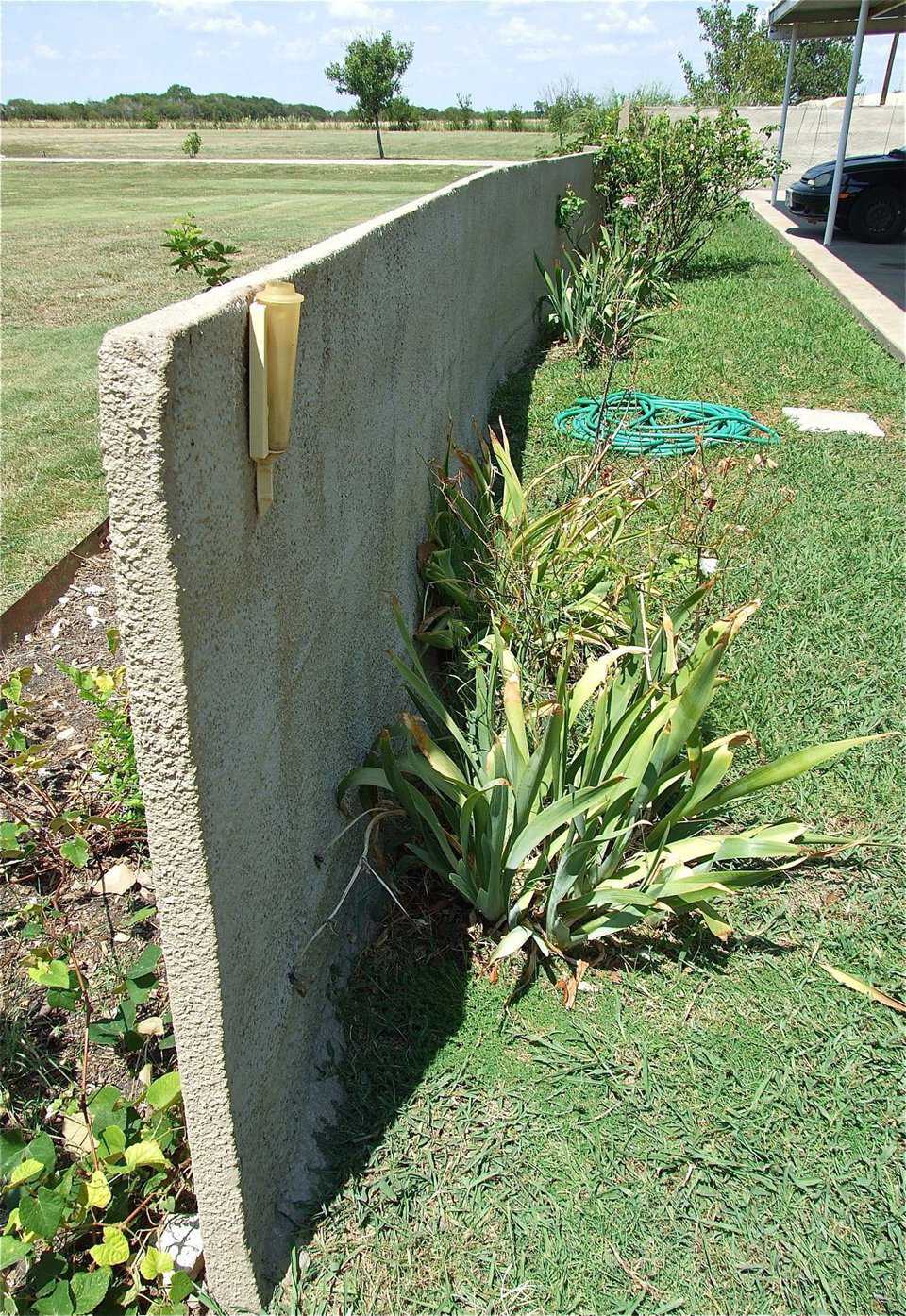 This view demonstrates how thin the layer of concrete fence actually is yet still surrounds the property as if it were a massive wall.