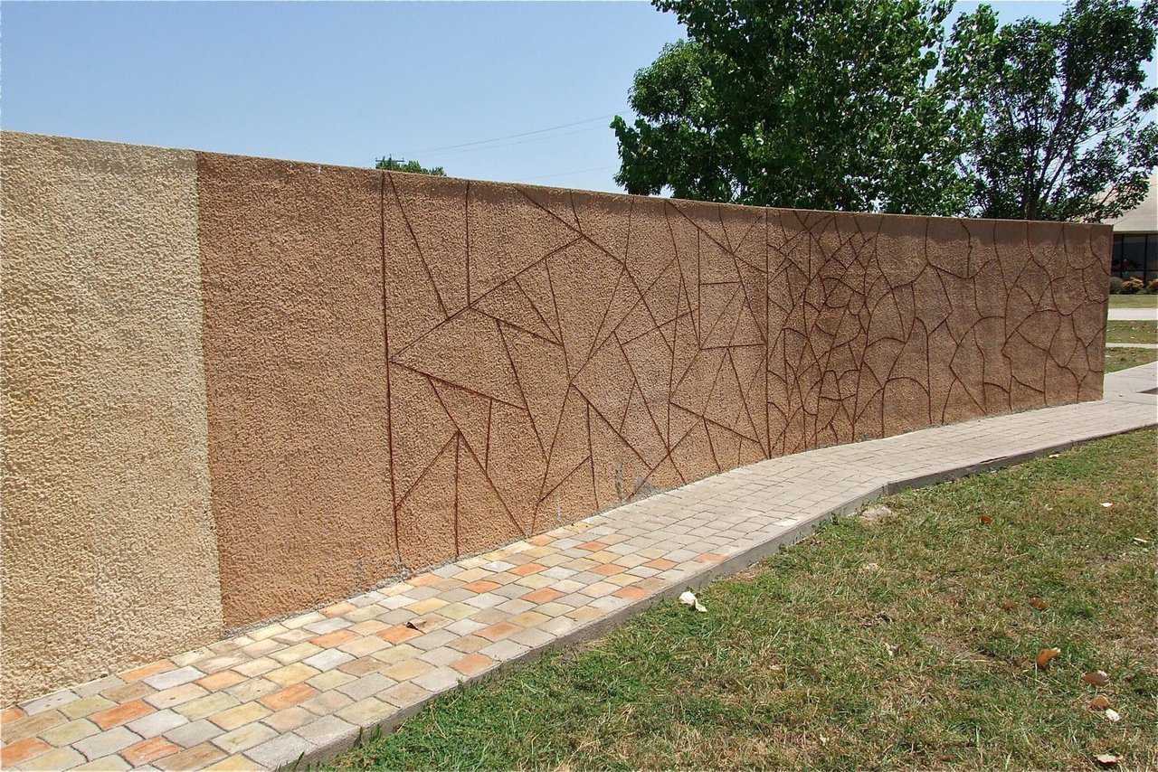 The backside of the corrugated sheet metal fence line shows color options and design treatments along a smooth surface.