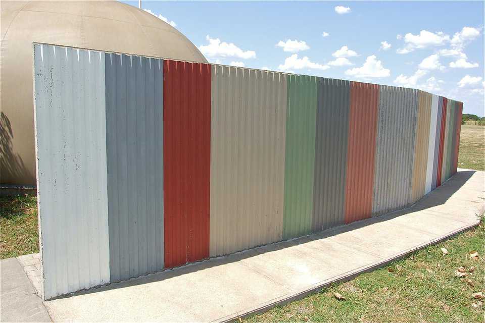 Sheet metal was used to created an endless symmetrical pattern down one side of this solid concrete fence.