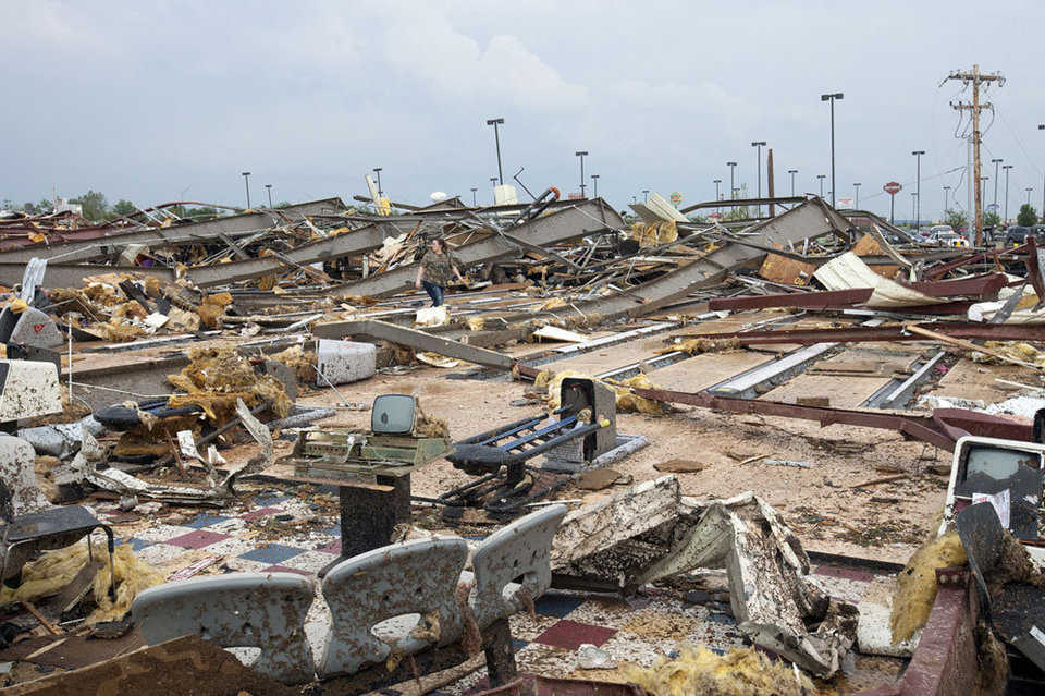 A woman walks through what remains of a bowling alley, and other buildings, after a huge tornado struck Moore, near Oklahoma City, on May 20, 2013.