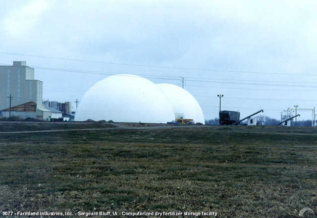 The modern, two Monolithic Dome, dry fertilizer storage facility of Farmland Industries, Inc. An advanced computerized system allows a small crew run the facility. The Monolithic Dome is very good at keeping the stored material dry and the concrete walls of the dome also resist the corrosive effects of the fertilizer.