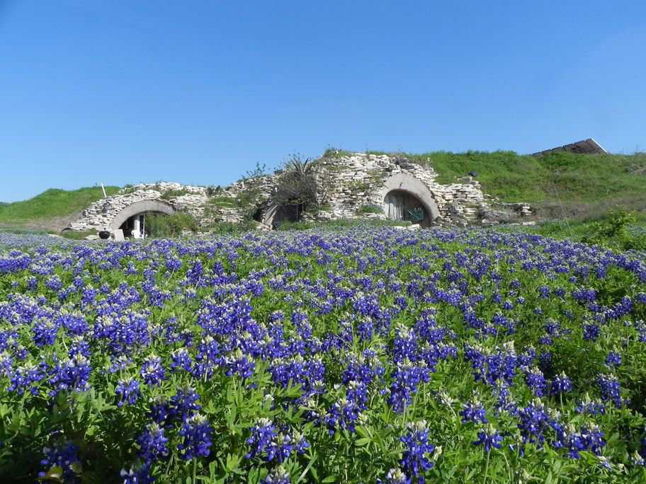 The Texas Blue Bonnets accentuate this picturesque, bermed Monolithic Dome home. Lovely stones surrounding the openings enhance the natural look.