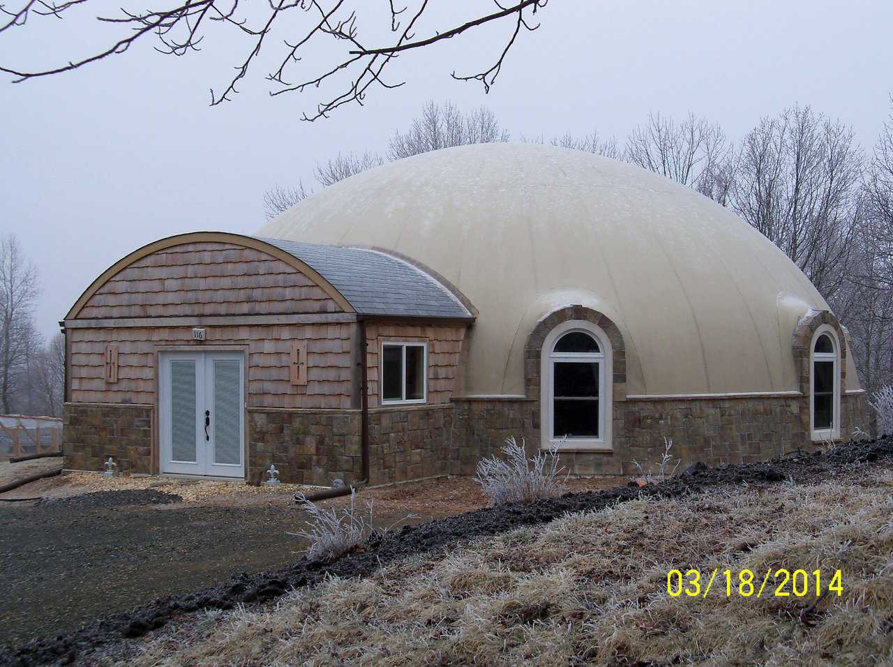 The trimmed out dome is spectacular. Note the rock wainscoat and the wood covered entryway. These really make the home beautiful for many generations.