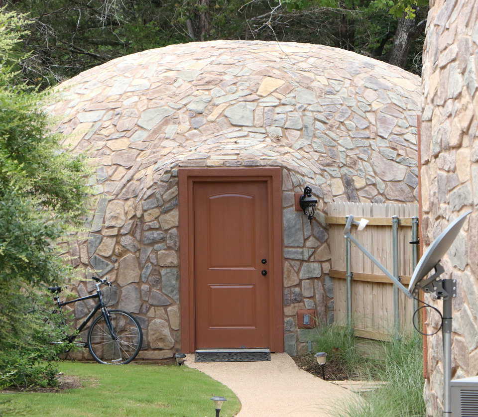 View from the backyard of the entrance to the Whiteacre’s Monolithic Dome garage, featuring beautiful stonework.