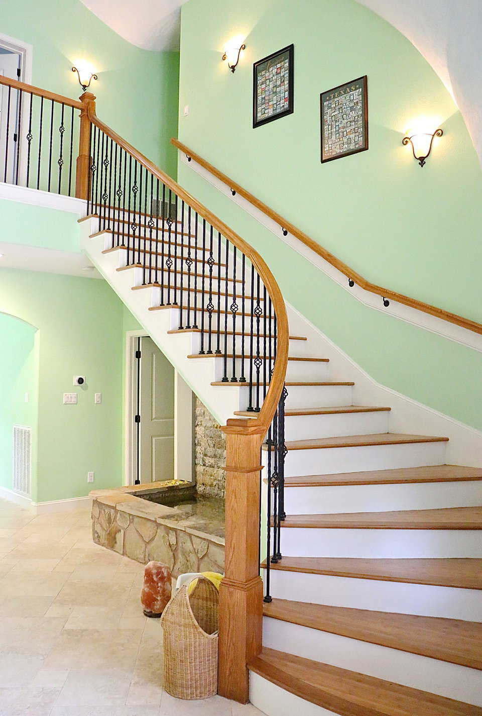 The Monolithic Dome Home’s entryway is dramatic and open all the way to the top of the dome. A grand staircase curves elegantly up to the second floor. Beneath the staircase, water gurgles in a rectangular, rock-covered fountain.