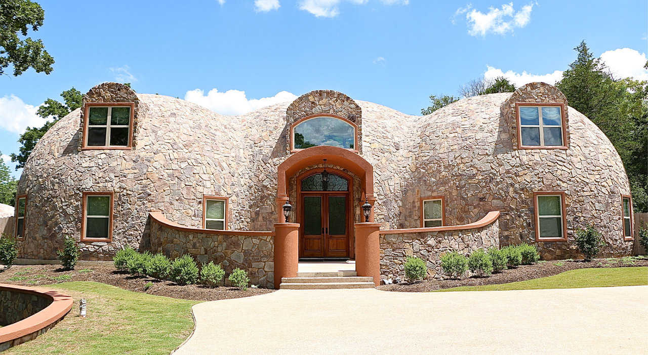 Welcome to Whiteacre! A sprawling Monolithic Dome Home that winds and curves its way around nearly 2 acres of plush landscaping.
