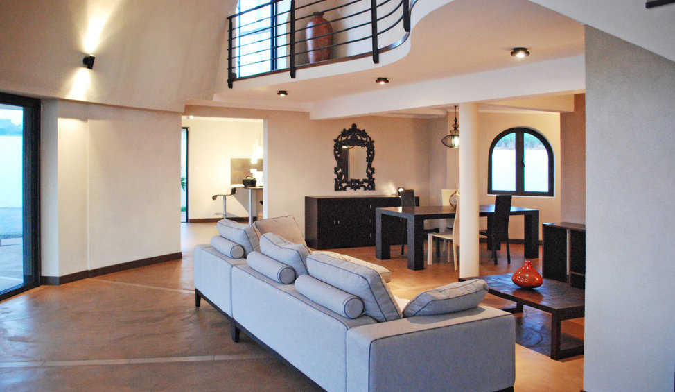 A gently curving balcony overlooks the open, airy living room.