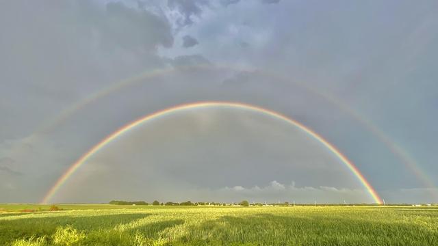 A double Texas-sized rainbow shines over a field during the Monolithic Dome Builders Workshop.